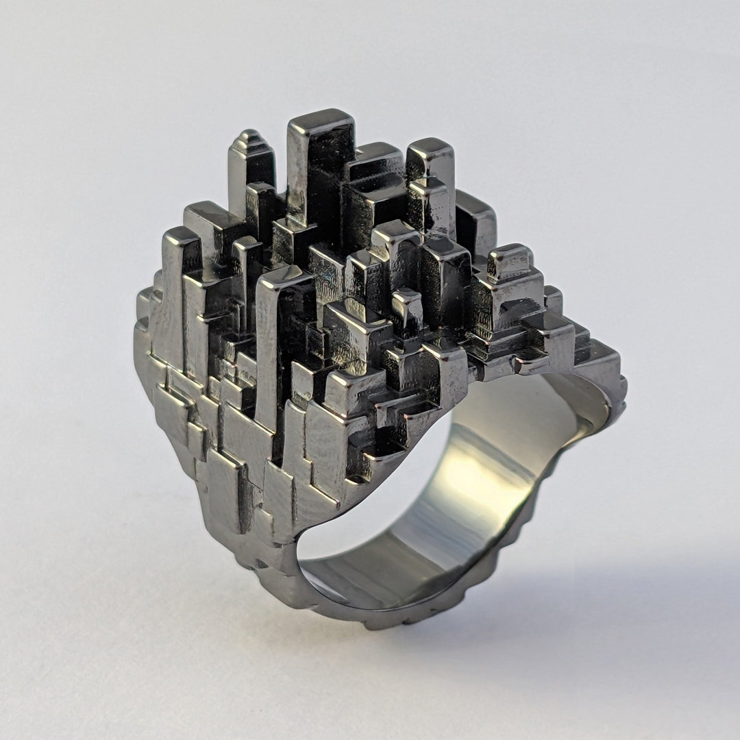 Bague en platine noire, sur un fond blanc de 3/4, elle semble chromée noir
